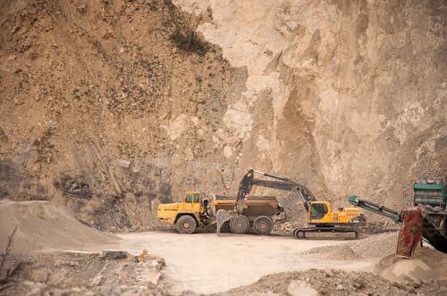 Free Excavator near industrial machines in quarry Stock Photo