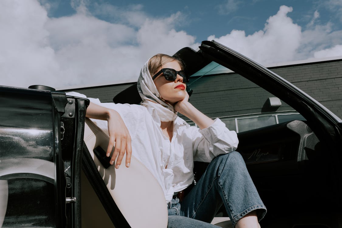 A Woman Sitting on a Car with a Convertible Top · Free Stock Photo