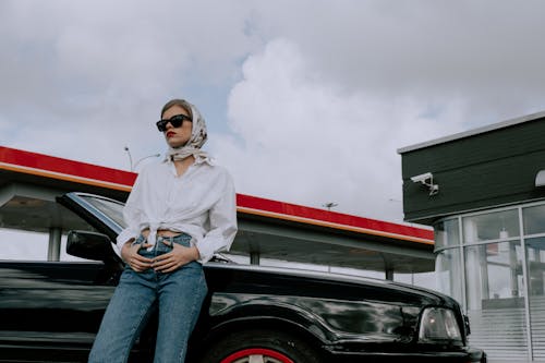 Wanita Dengan Kemeja Lengan Panjang Putih Dan Jeans Denim Biru Duduk Di Mobil Hitam