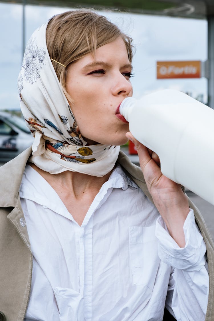 A Woman Drinking Milk On The Container