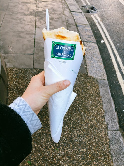 A Person Holding a Wrapped Crepe 