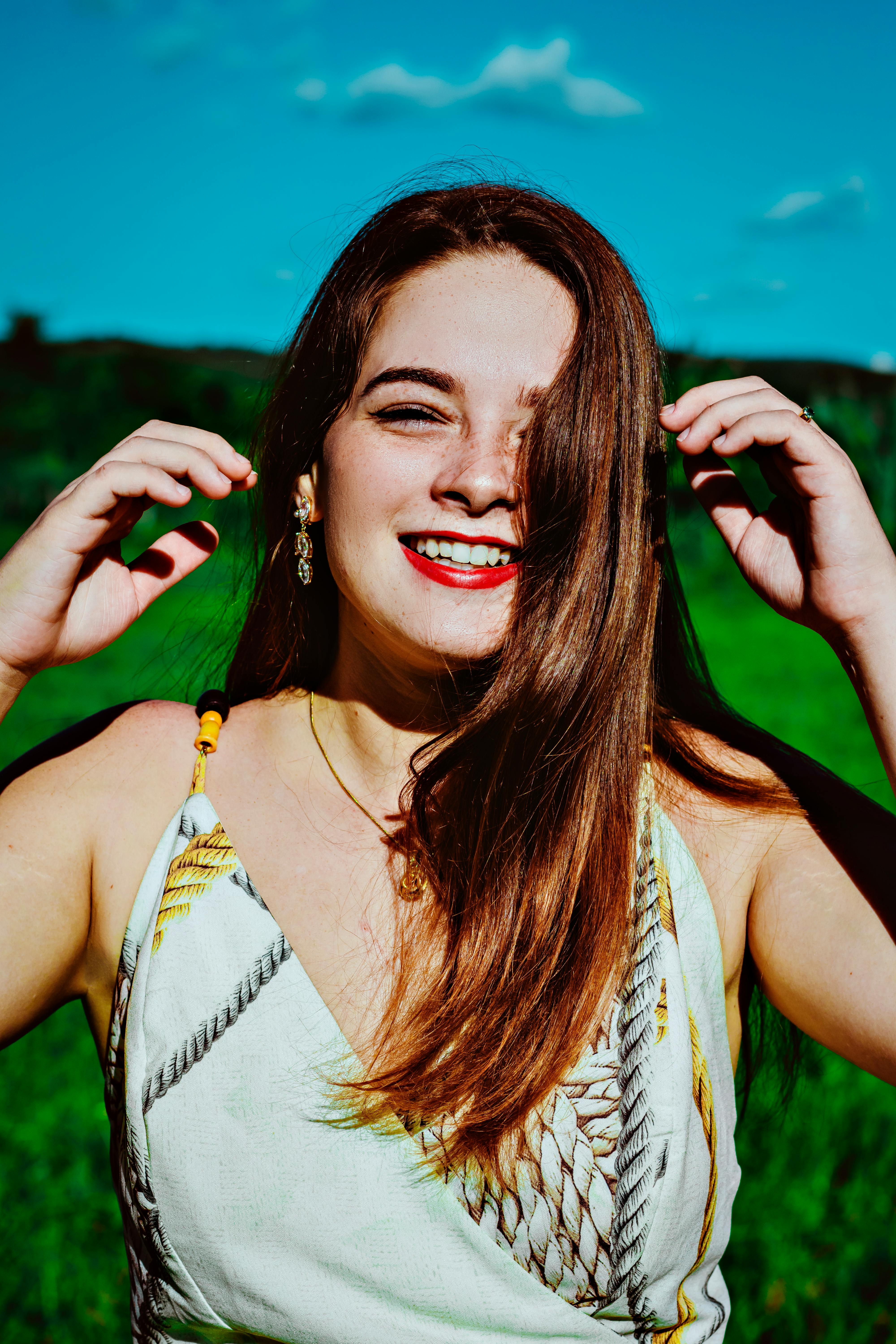 A joyful portrait of a woman laughing in a summer setting, capturing bright emotions.