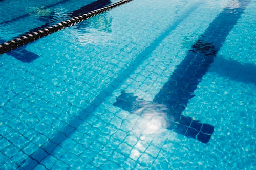 Shiny blue water in swimming pool with lane marker