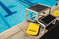 Diving board in swimming pool with blue water
