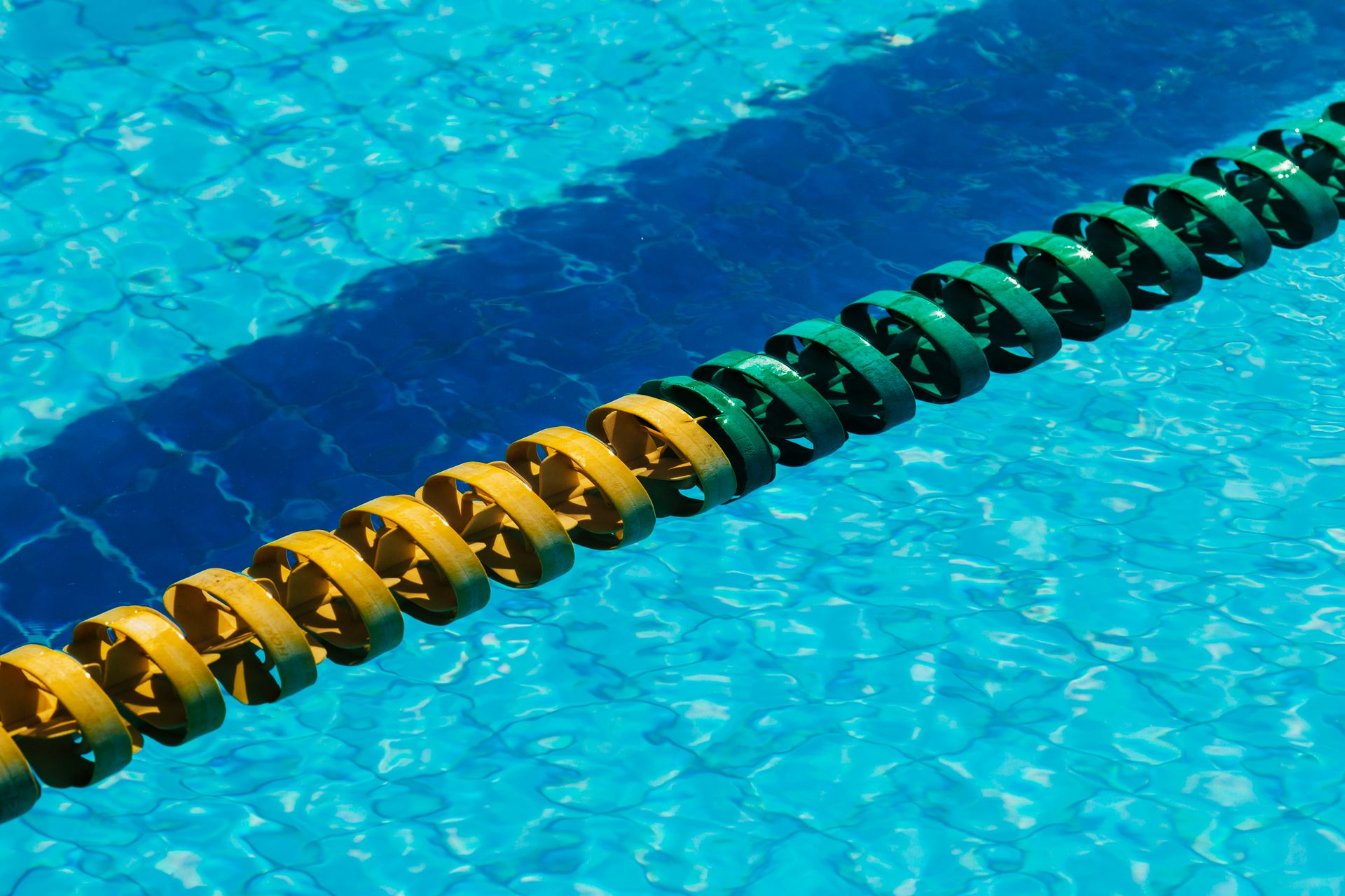 From above of roll shaped divider with ribbed surface in swimming pool with shiny blue water