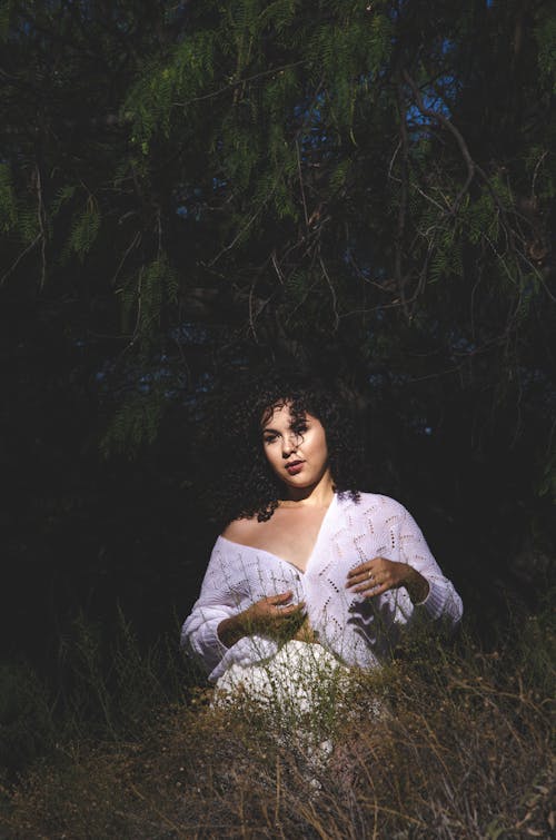 Young stylish woman standing in grassy garden