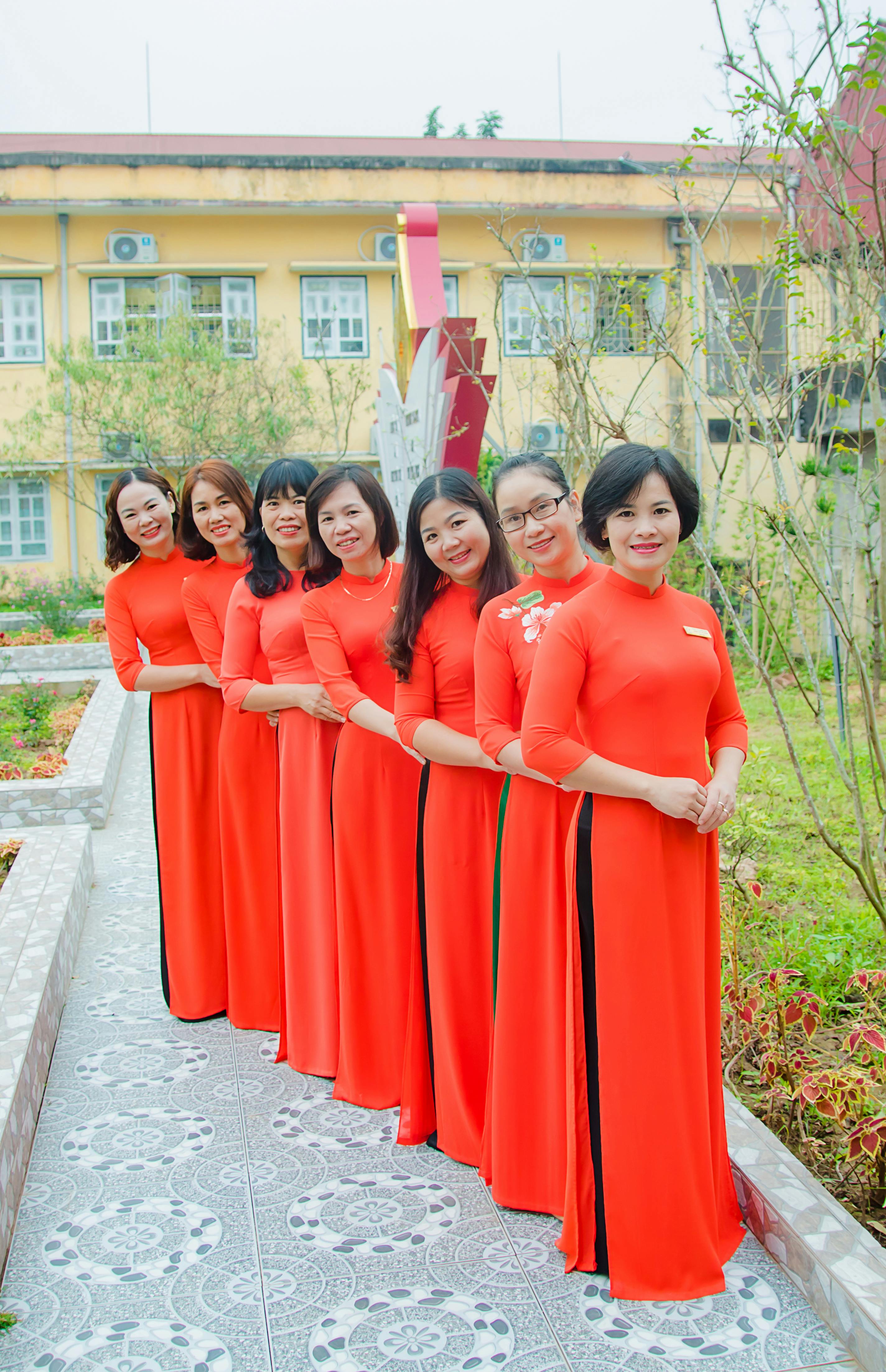 group of women in red dresses posing together