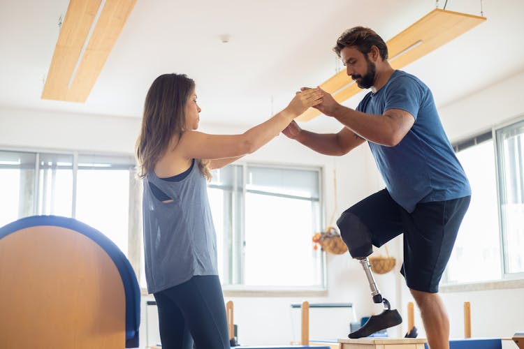 A Woman Guiding A Man On His Physical Therapy