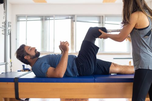 Free Man and woman engaging in a physical therapy session, focusing on prosthetic leg recovery and rehabilitation. Stock Photo