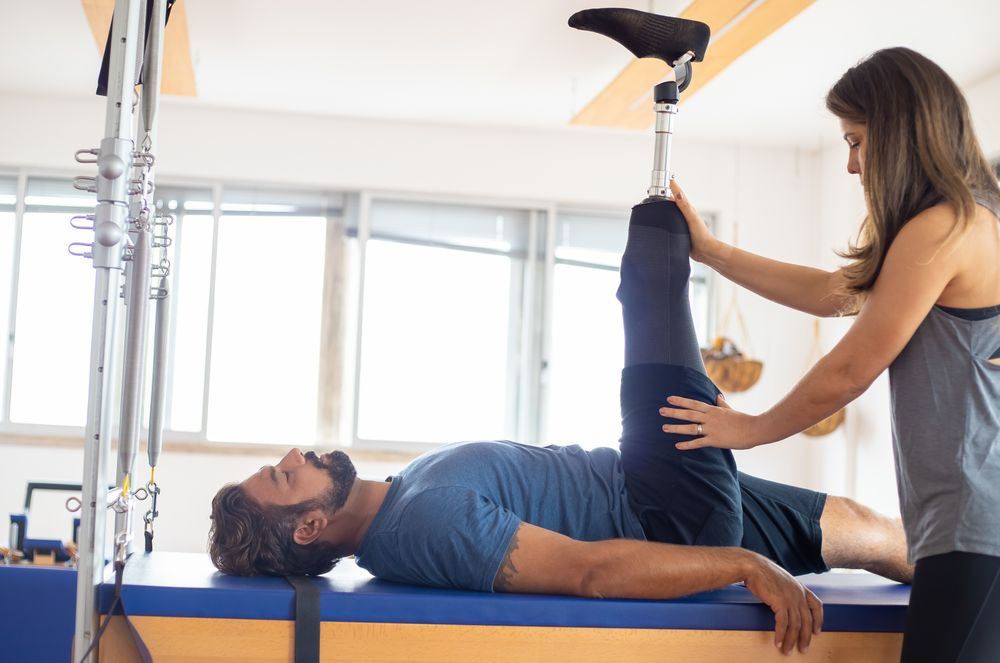 Coach guiding a client through a rehab and training exercise at Metcons Fitness