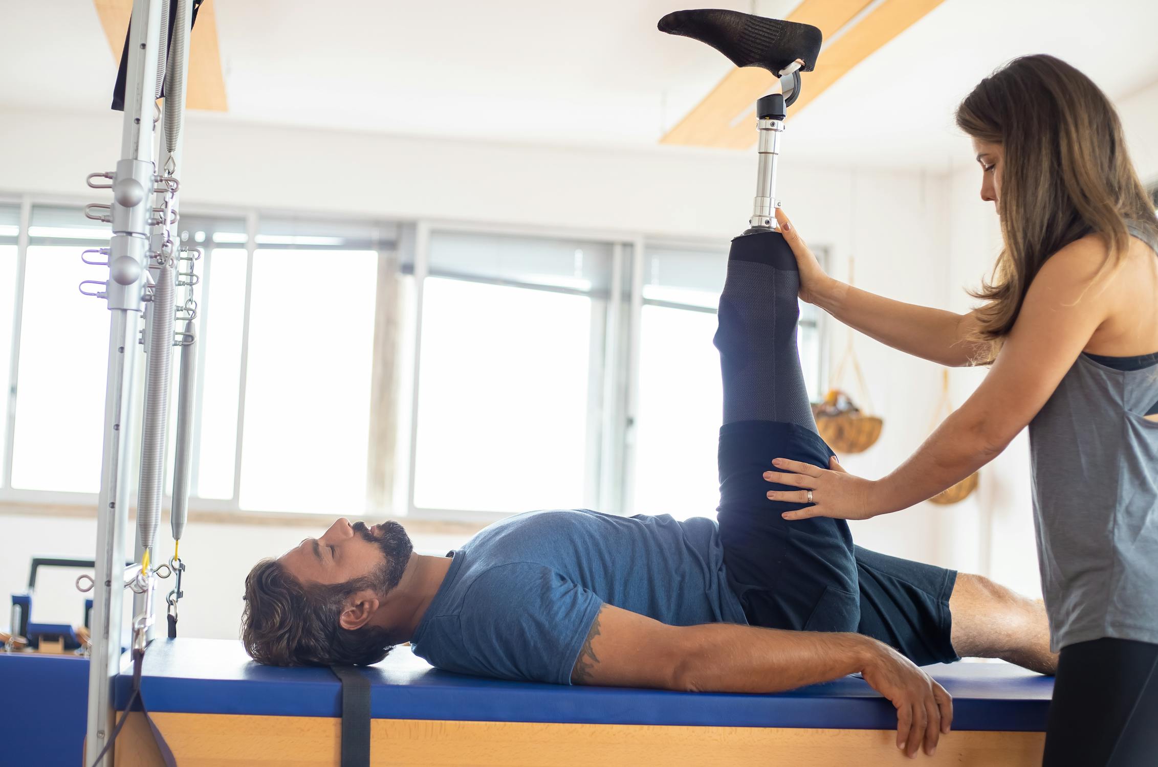A caregiver assisting a person with a robotic prosthetic leg