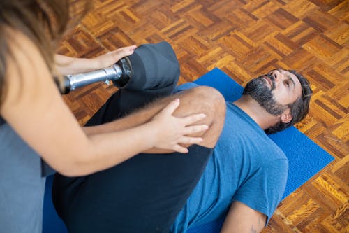 Homme En T Shirt à Col Rond Bleu Et Bonnet En Tricot Noir Assis Sur Un Tapis Bleu