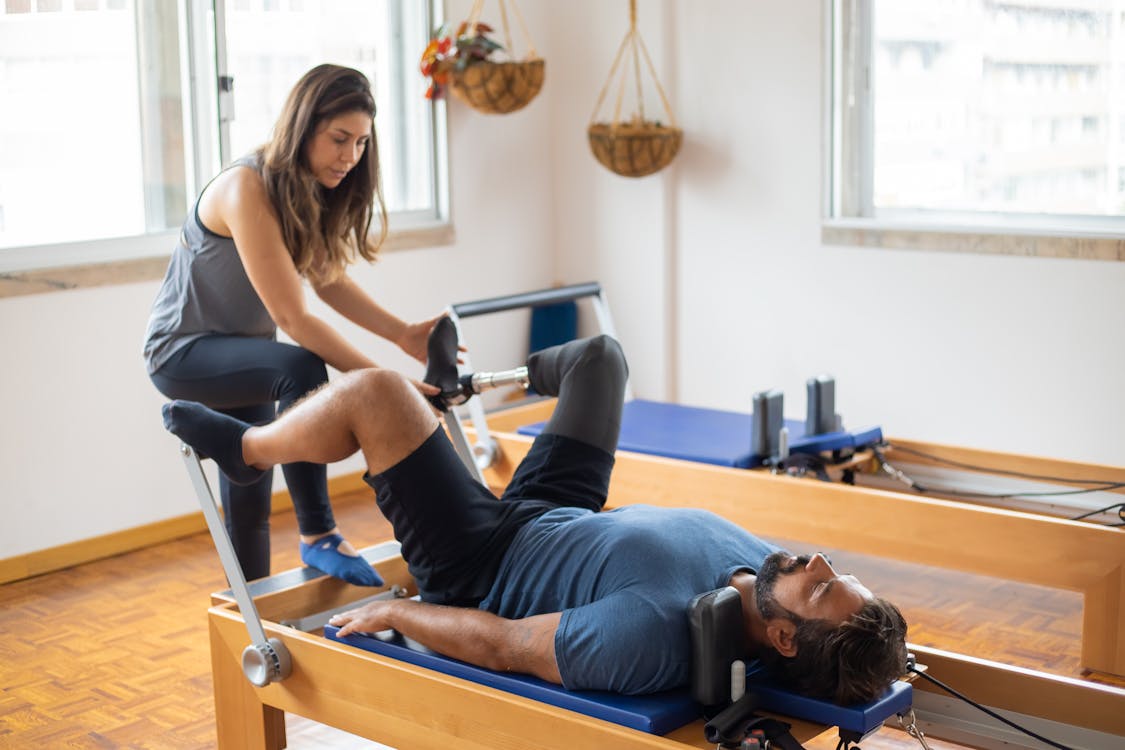 A Woman in Activewear Doing Pilates Reformer Exercise · Free Stock