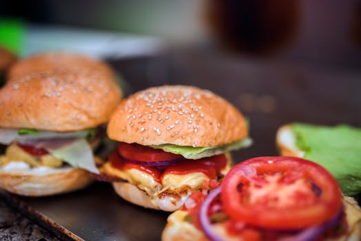 Close-up of tasty cheeseburgers with fresh lettuce and tomato, perfect for food lovers.