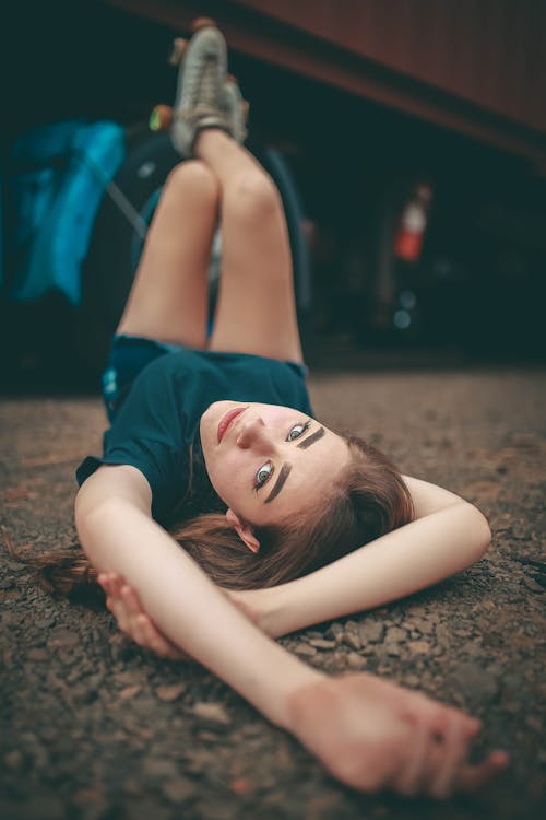 Woman in Blue Shirt Lying on Ground