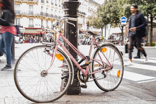 Pink City Bike Leaning on Black Post