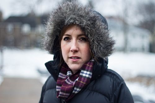 Free A young woman in a fur-trimmed hooded jacket standing outdoors in winter snow. Stock Photo