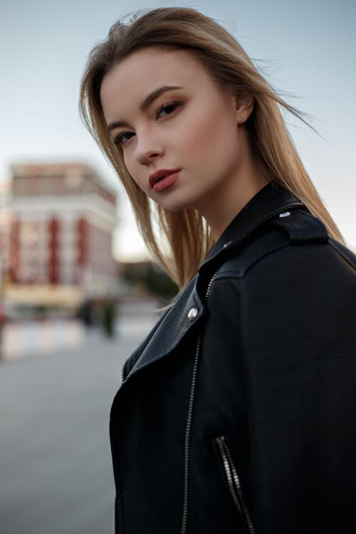 Free Young woman in trendy jacket on street of city Stock Photo