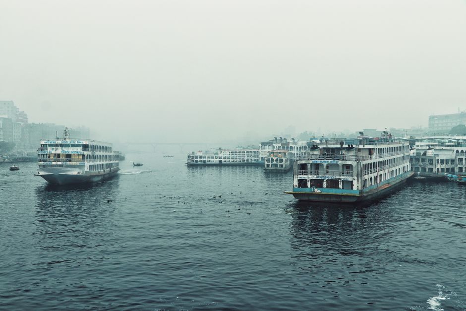 Ferries navigate the Buriganga River in Dhaka, showcasing urban water transport.