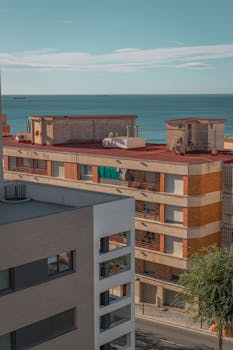 A view of modern apartments in Tarragona overlooking the Mediterranean Sea on a sunny day.
