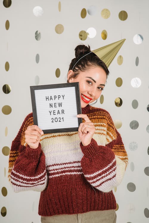 Positive woman showing blackboard with holiday inscription