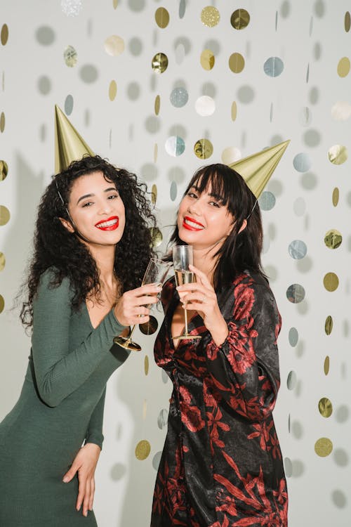 Stylish women clinking with champagne glasses