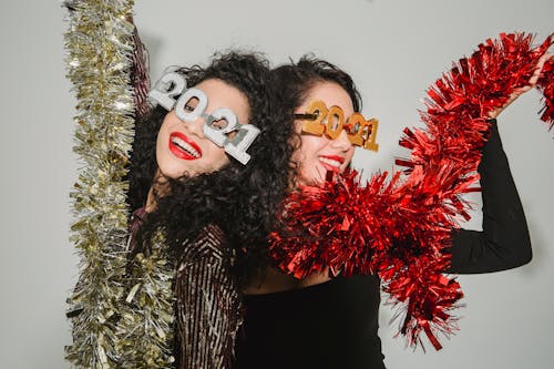 Cheerful women with tinsel celebrating new year