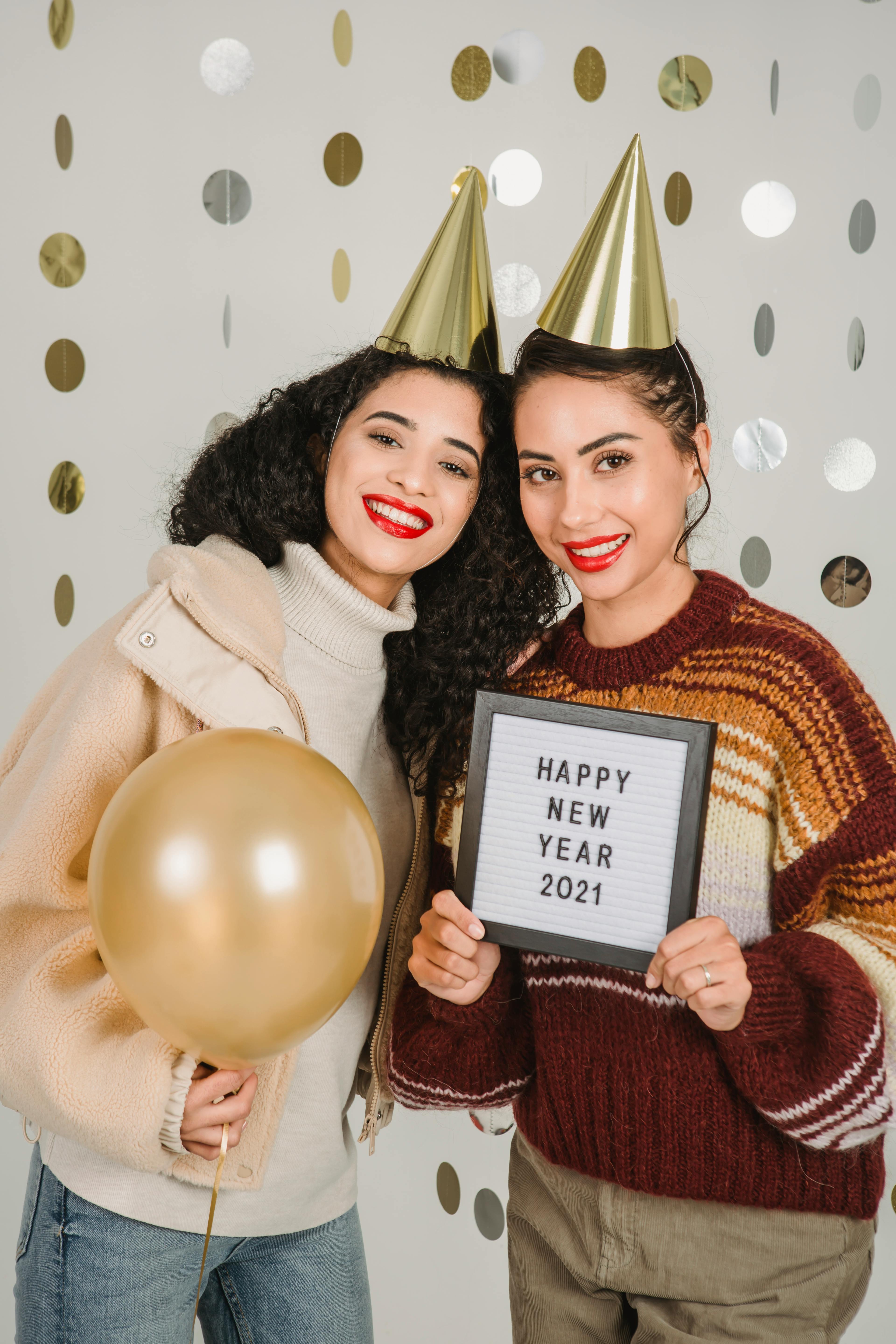 happy women in party hats celebrating new year