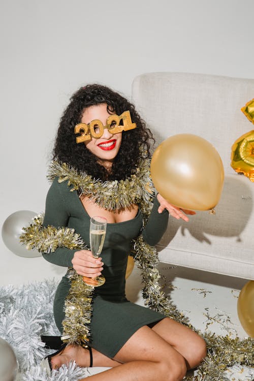 Happy woman in festive glasses and tinsel smiling