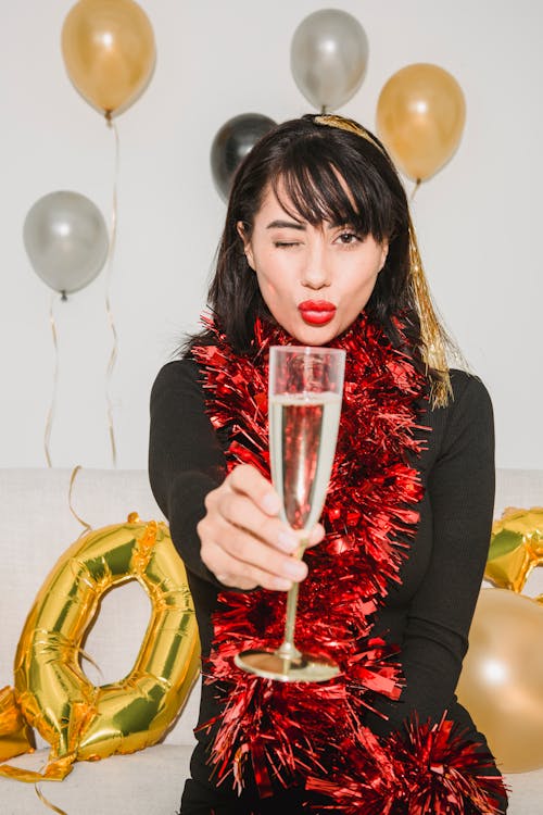 Content woman winking and showing glass of champagne