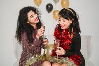 Cheerful women with glasses of champagne among balloons