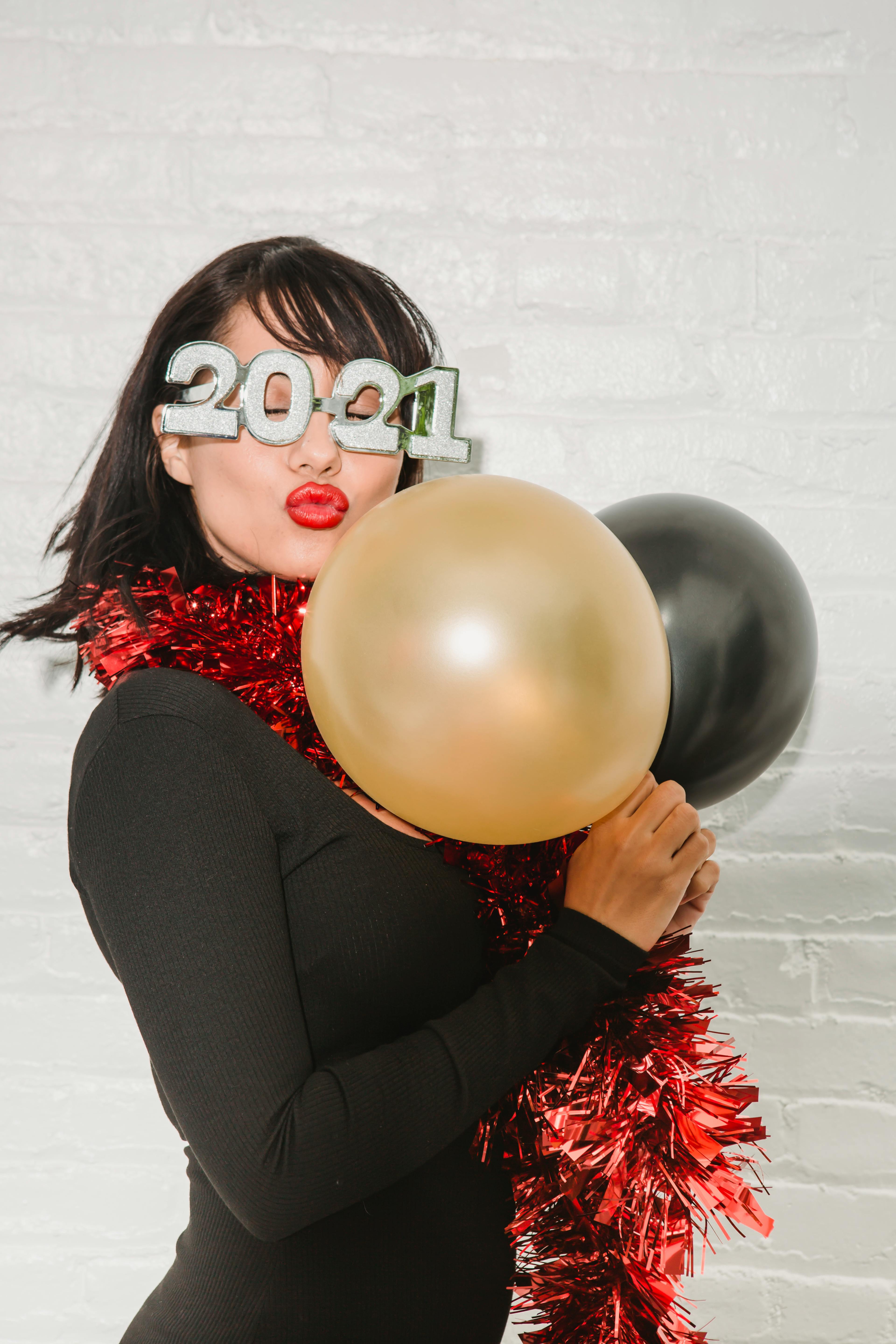 happy woman in decorative new year eyeglasses with shiny balloons