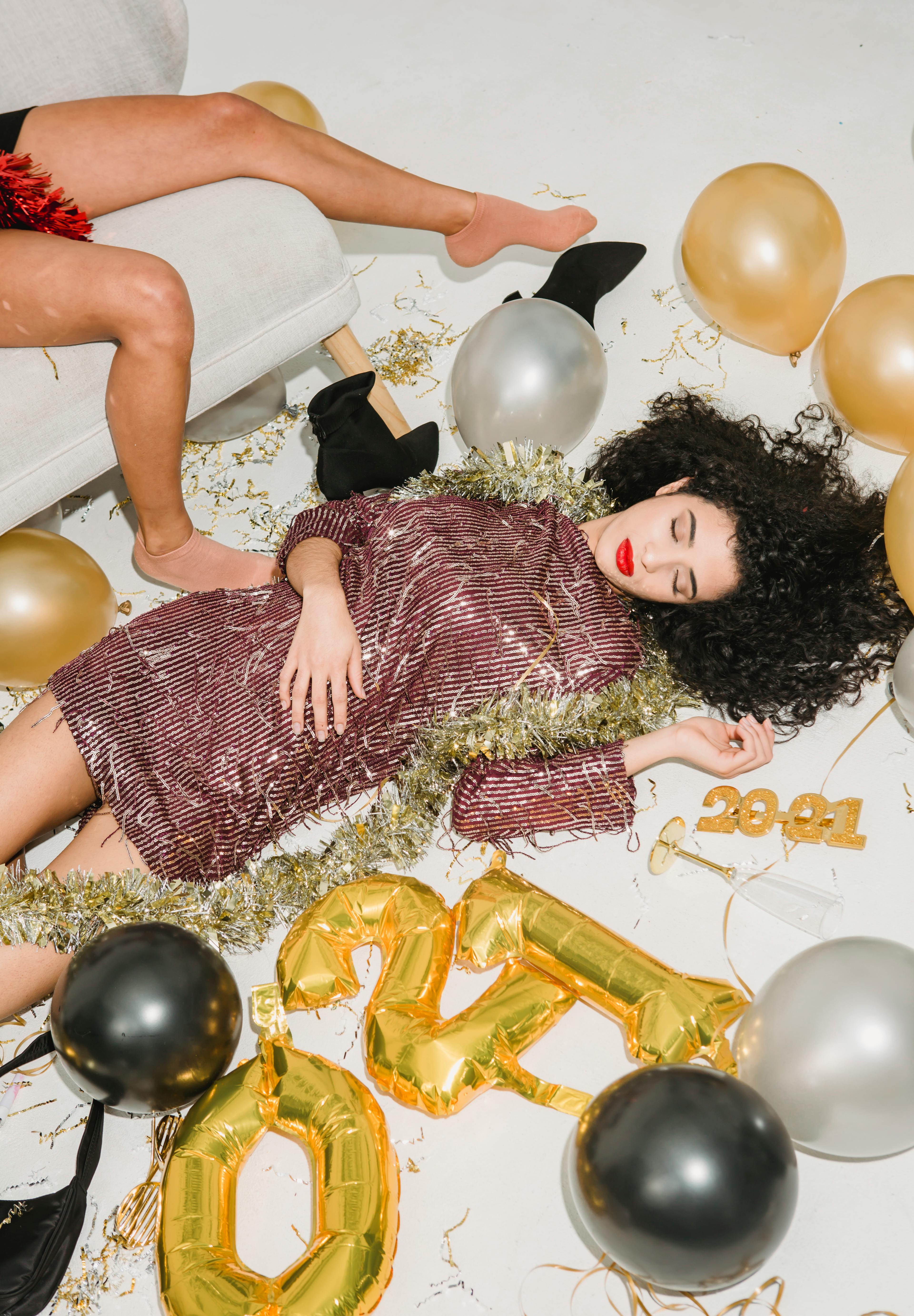 drunk women sleeping among balloons after new year party