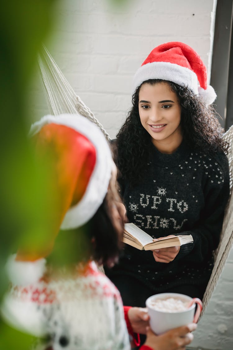 Cheerful Friends In Christmas Clothes Drinking Coffee In Cafe