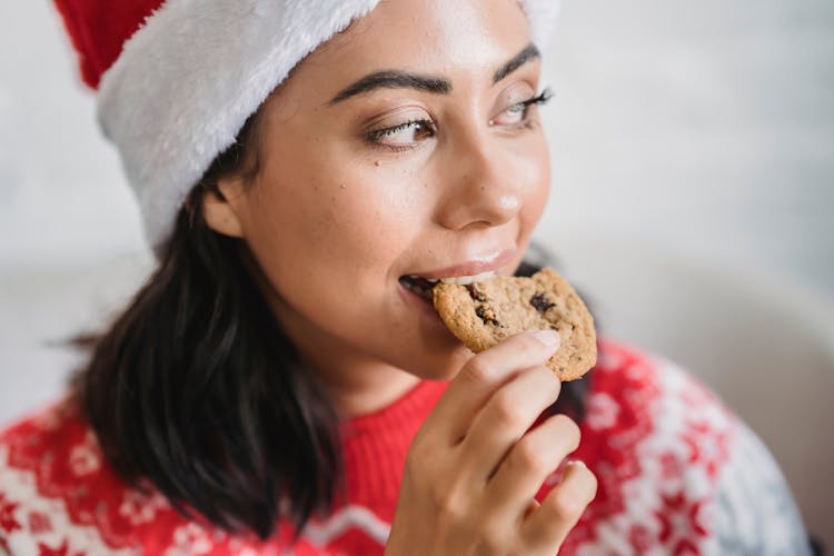 Female Biting Cookie In House In Christmas