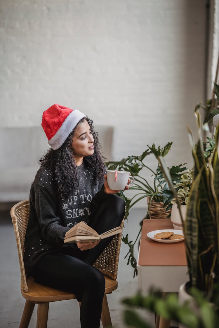 Ethnic Female In Room With Book And Cup Of Drink