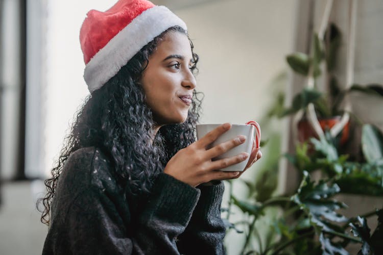 Cheerful Woman In Christmas Hat With Hot Cocoa At Home