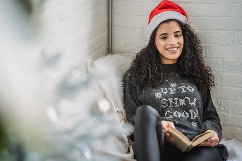 Cheerful woman with book sitting in armchair