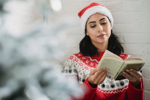 Thoughtful woman reading book in room