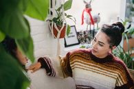 From above of young female in casual clothes sitting on comfortable couch and talking to friend while resting in cozy room