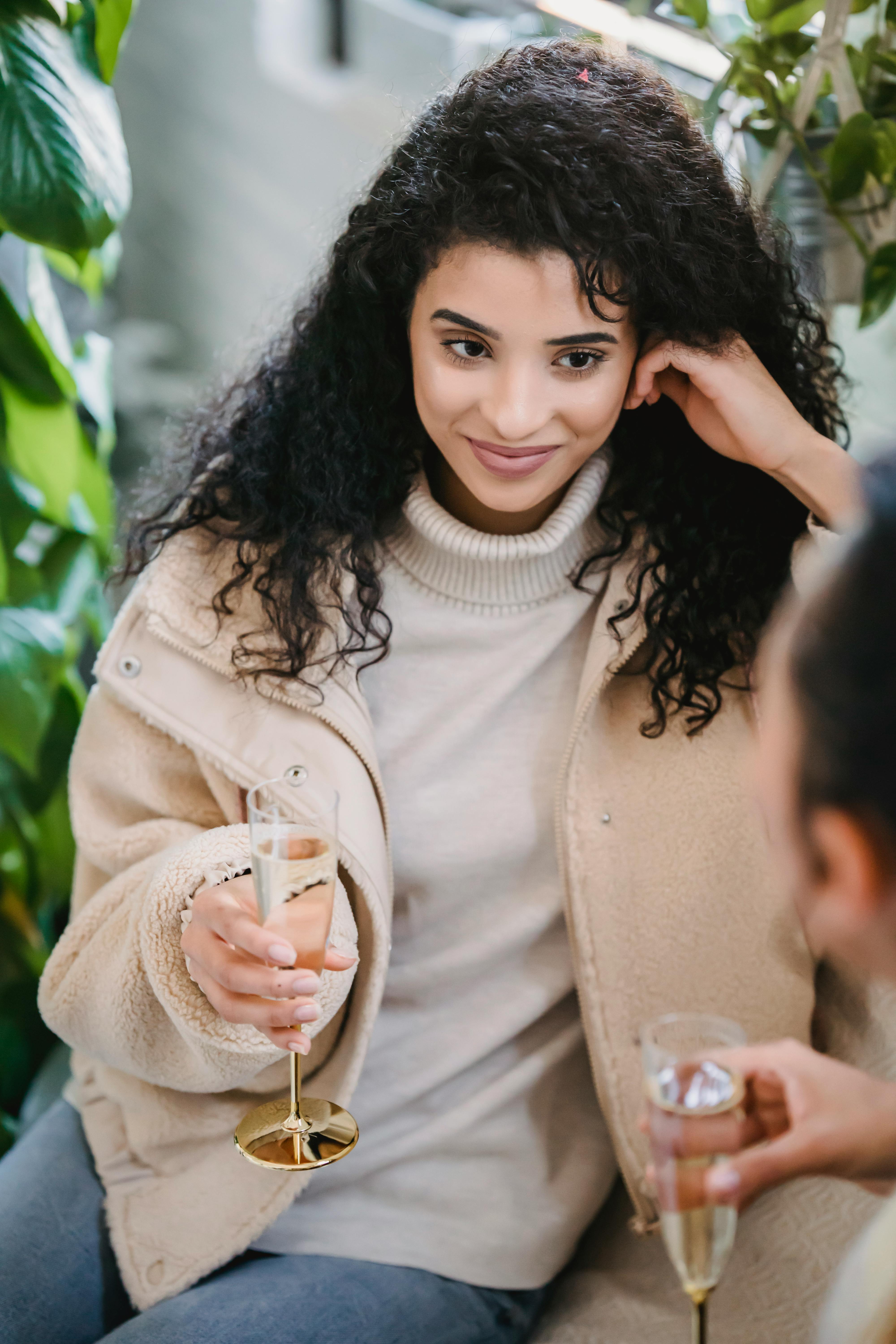 happy woman with glass of champagne resting with friend at home