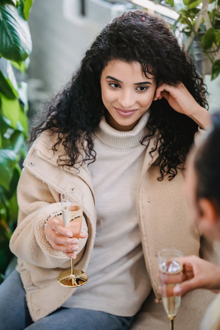 Happy Woman With Glass Of Champagne Resting With Friend At Home