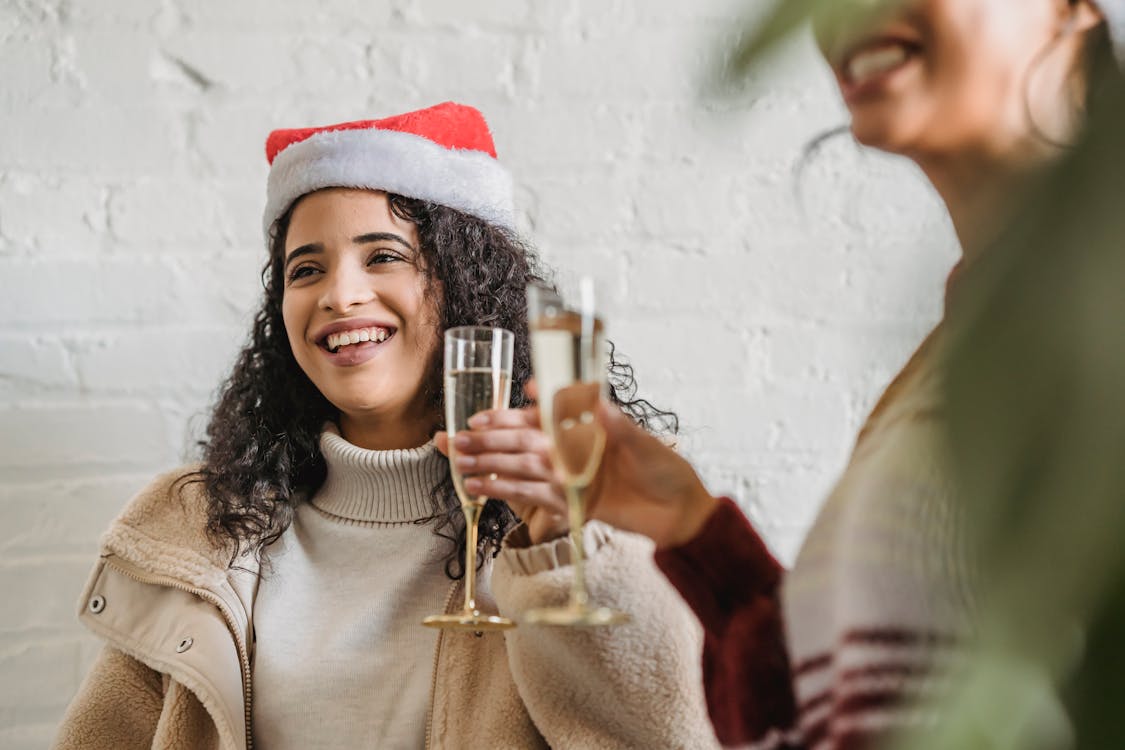 Happy young women toasting with champagne on Christmas party