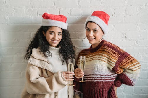 2 Gadis Memakai Topi Santa Memegang Kacamata