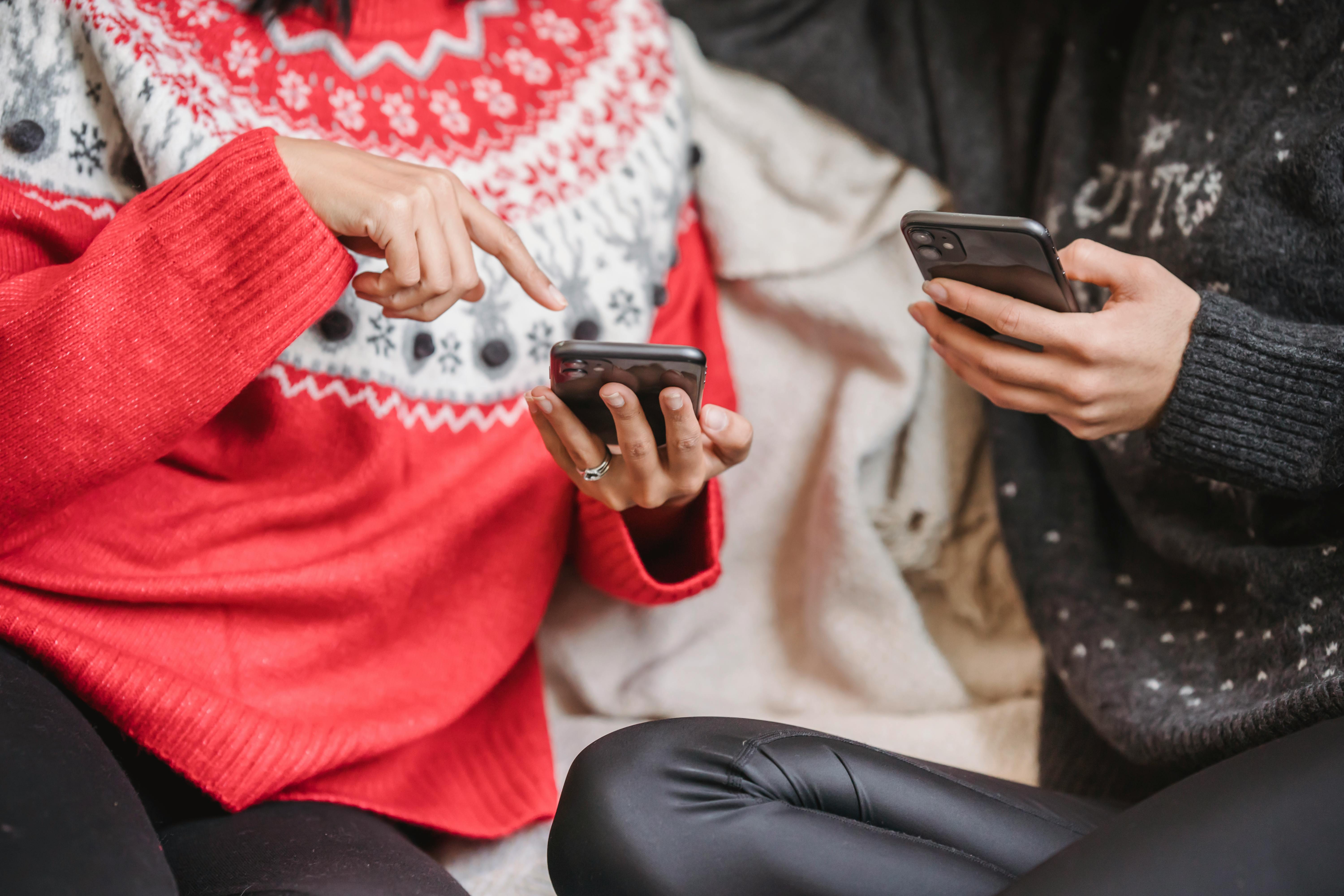 woman browsing smartphones on couch together