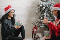 Excited ethnic friends exchanging gifts for Christmas