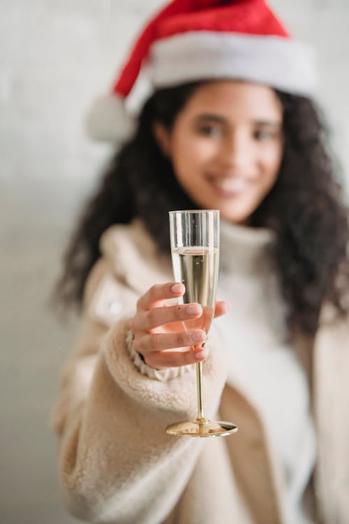 Smiling ethnic woman toasting with glass of champagne