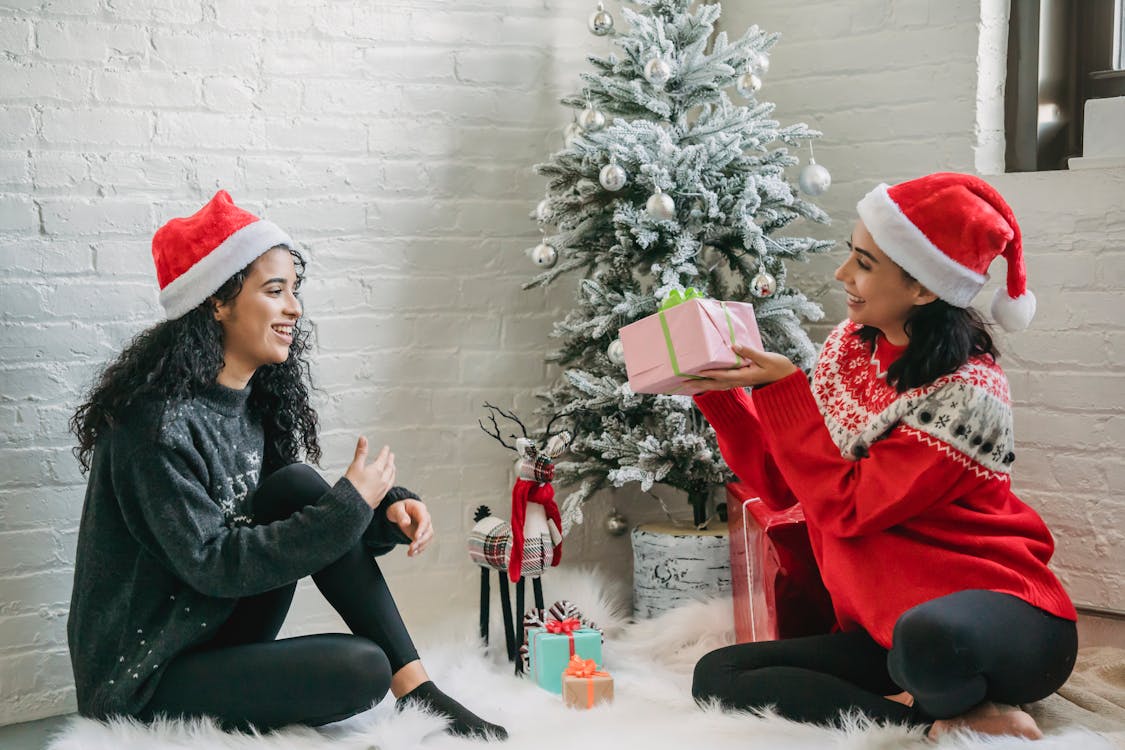 Free Happy ethnic friends exchanging gifts for Christmas Stock Photo