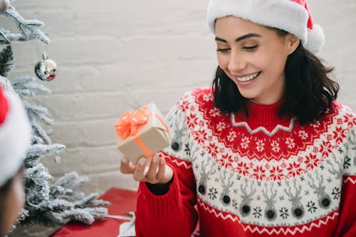 Ragazza Sorridente In Maglione Rosso E Bianco Che Tiene Cupcake Rosa E Bianco