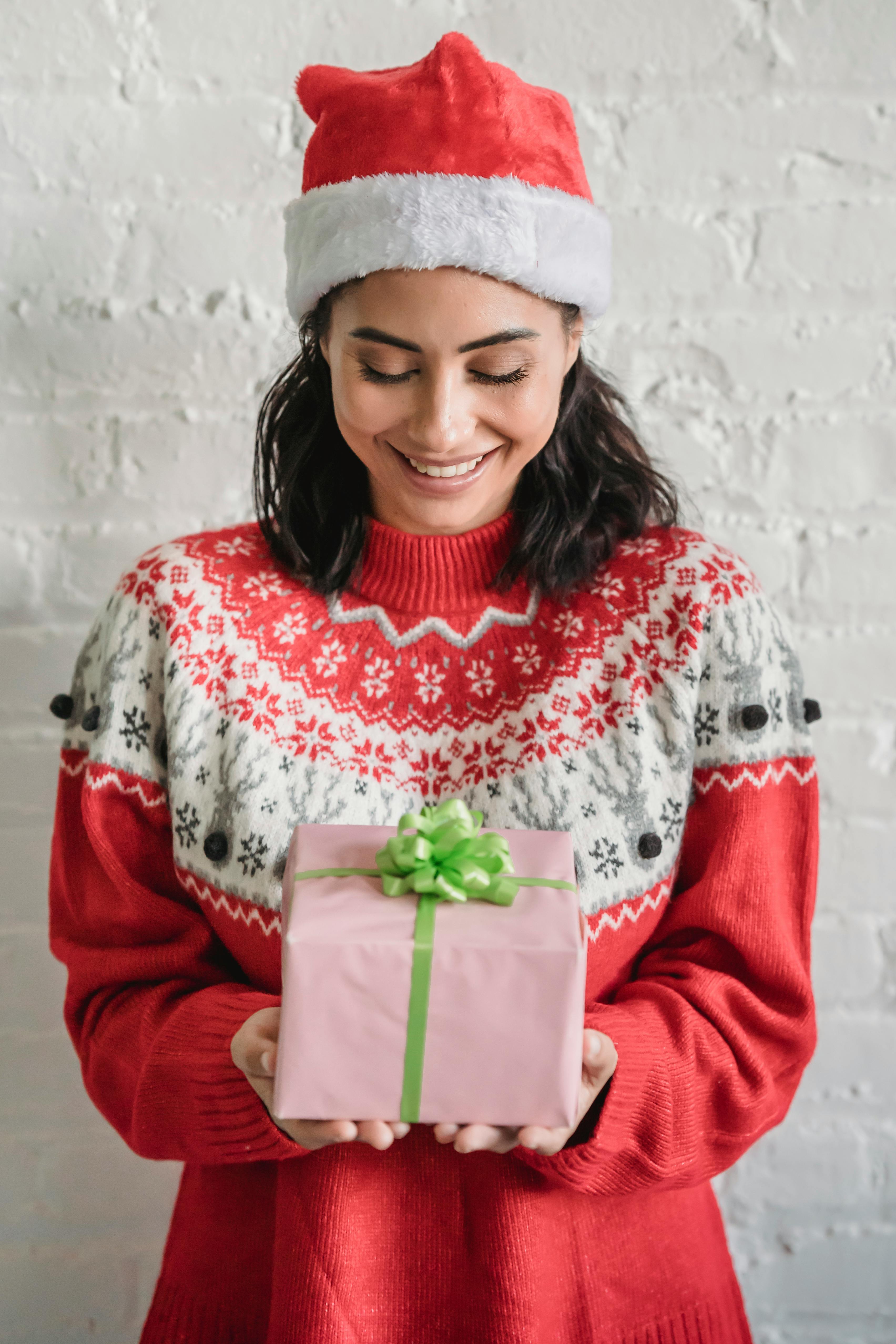 smiling ethnic woman with christmas gift decorated with bow